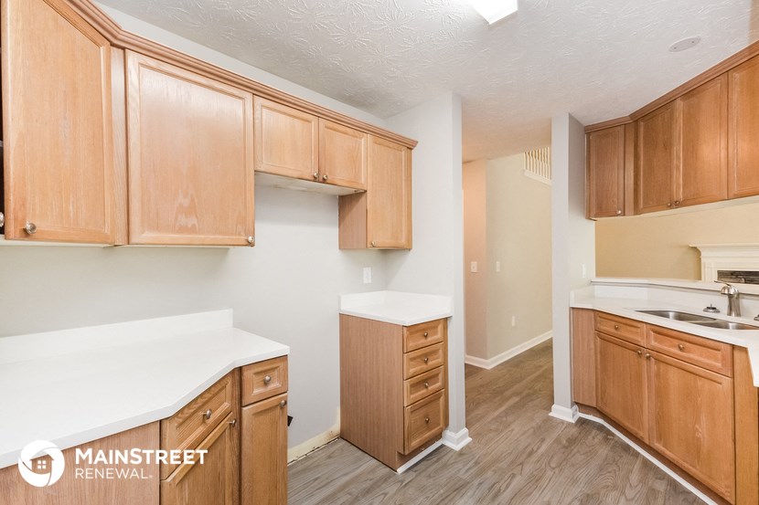 a kitchen with wooden cabinets and white counter tops and a white counter top on top
