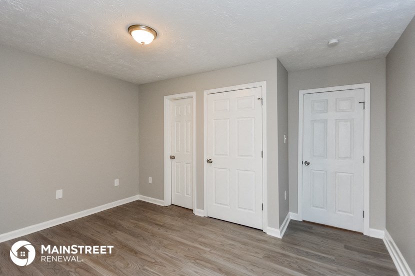 the spacious living room with two doors to the closet