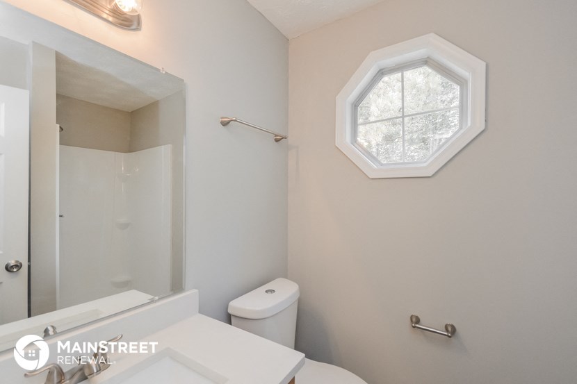 a small bathroom with a white toilet and a window
