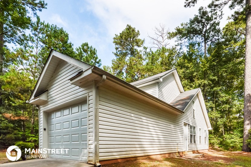 a garage with white siding and a white garage door