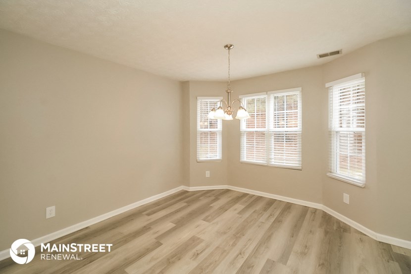 the spacious dining room with wood flooring and windows