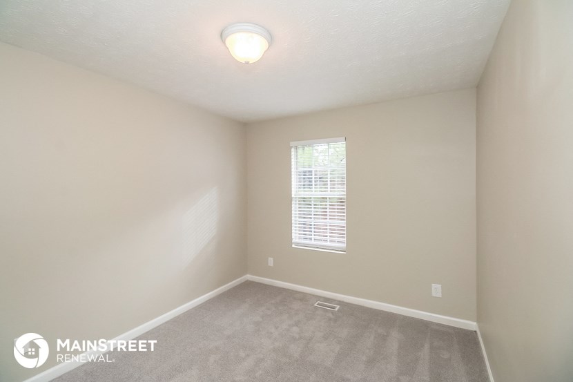 a bedroom with a carpeted floor and a window