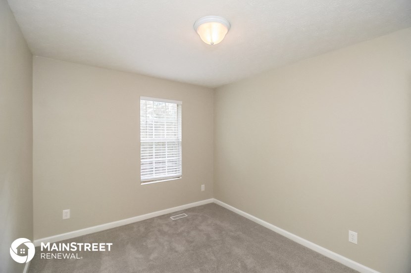a bedroom with a carpeted floor and a window