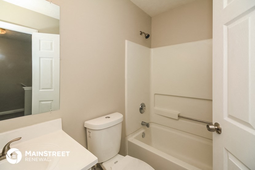 a bathroom with a toilet and a tub and a sink