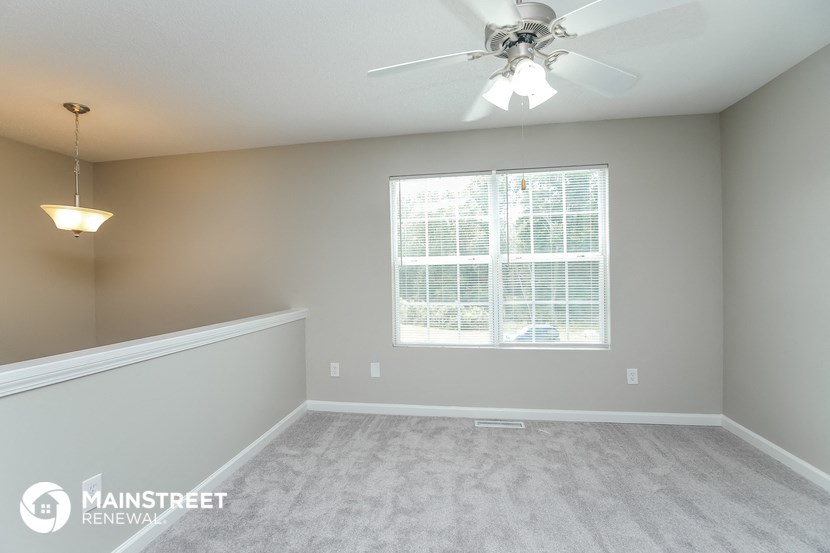an empty room with a ceiling fan and a window