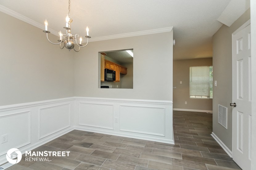 the dining room has a large window and a chandelier