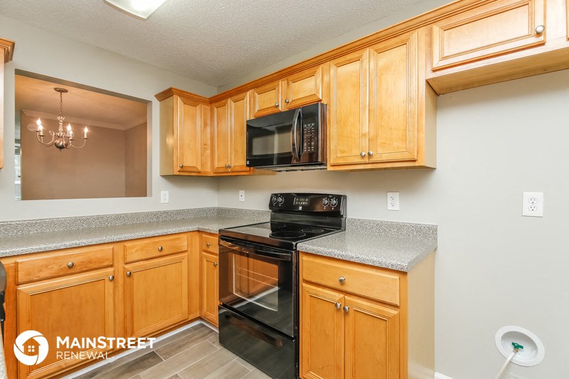 a kitchen with black appliances and wooden cabinets