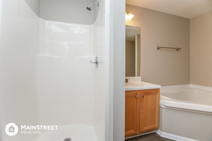 a bathroom with a shower and a sink and a mirror