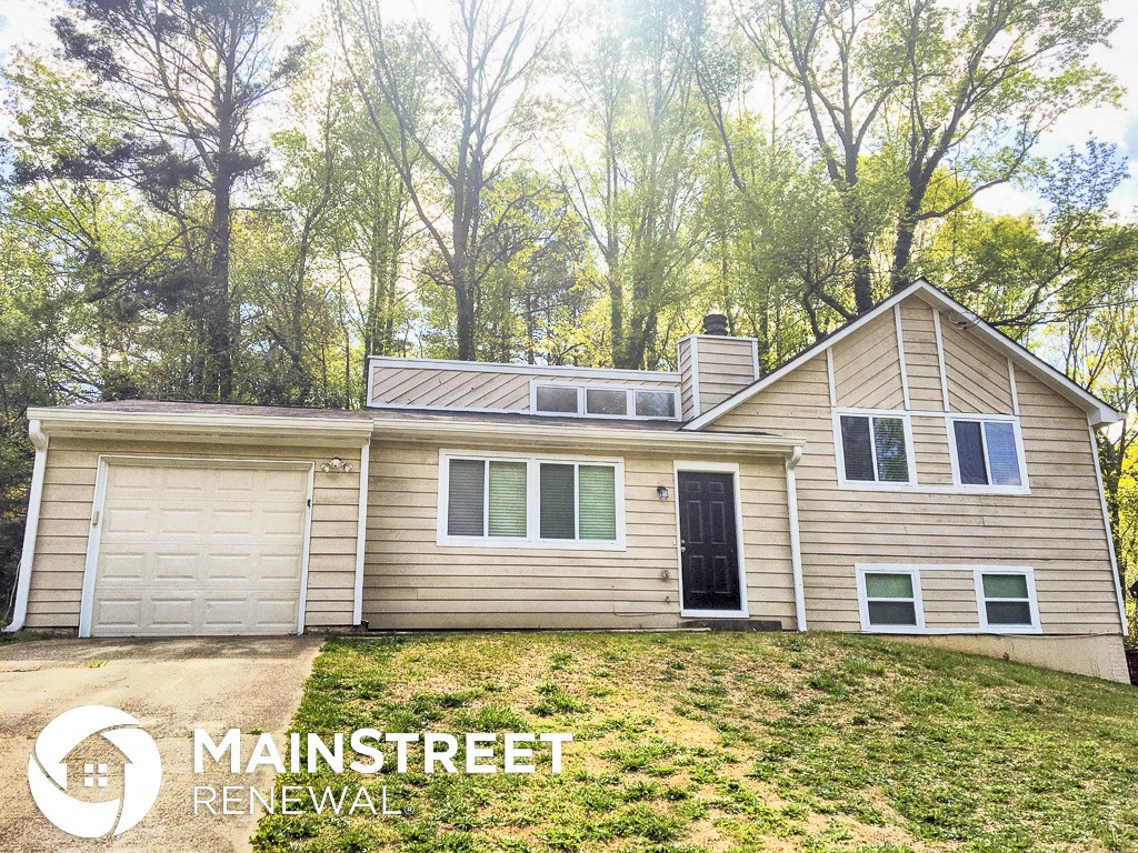 a house with a garage and a roof on top of a hill