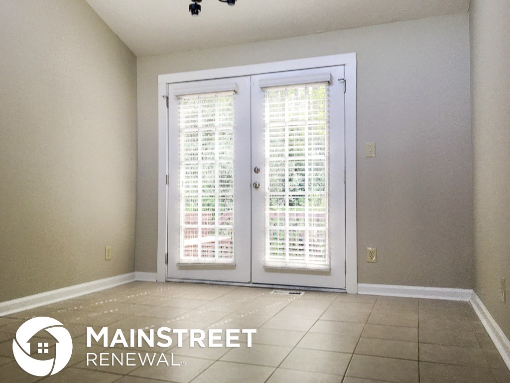 an empty living room doors and a tile floor