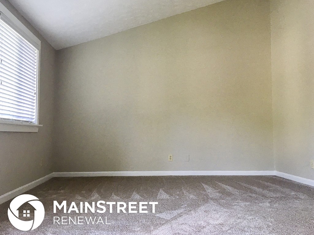 an empty room with white walls and a window