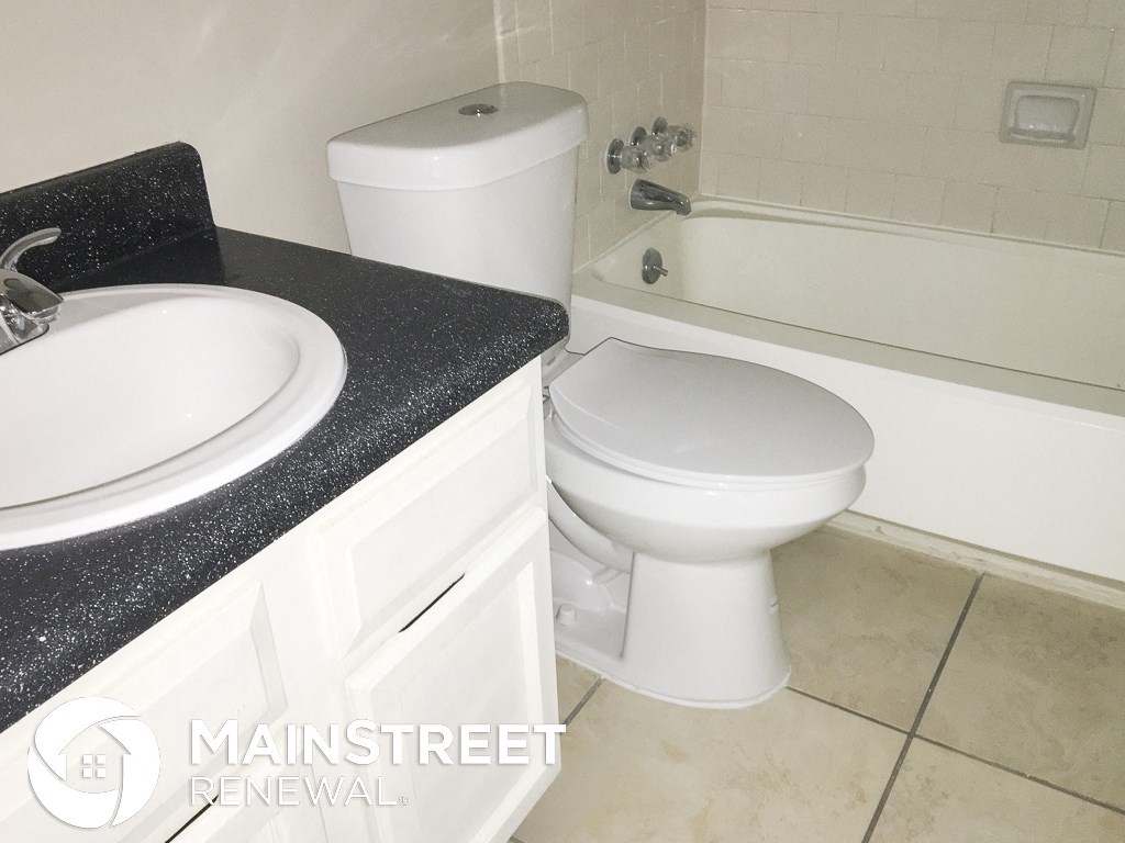 a bathroom with a toilet and a sink and a tub