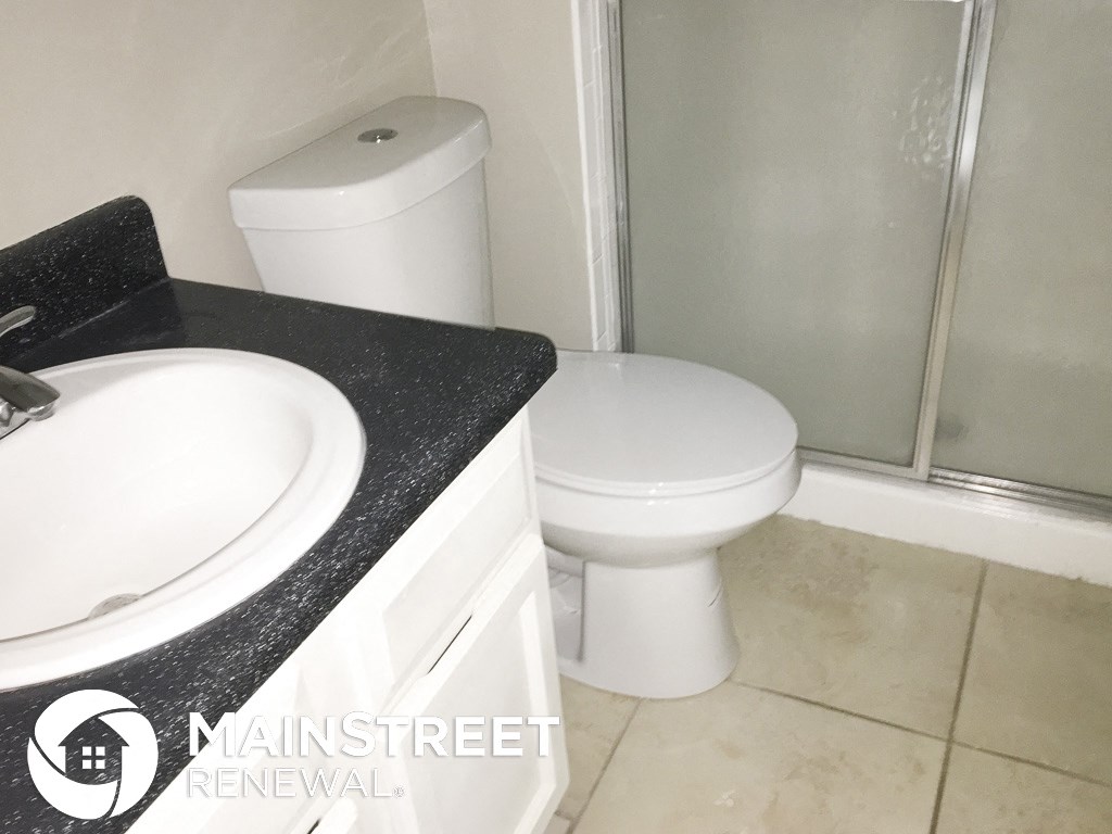 a bathroom with a toilet and a sink and a shower