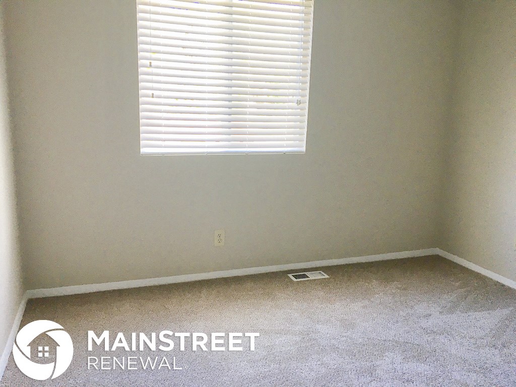 a small room with a window and a carpeted floor