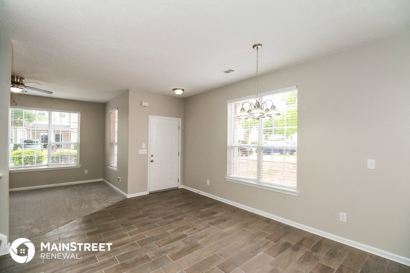 an empty living room with wood floors and a white door