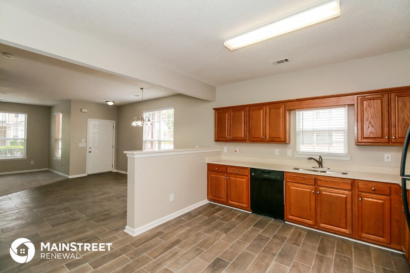 a kitchen and living room with wood flooring and wooden cabinets