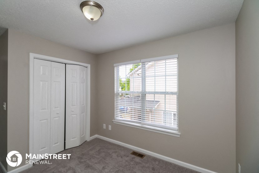 the living room of an apartment with a large window and a closet