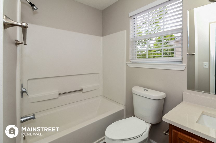 a bathroom with a toilet and a bath tub and a sink