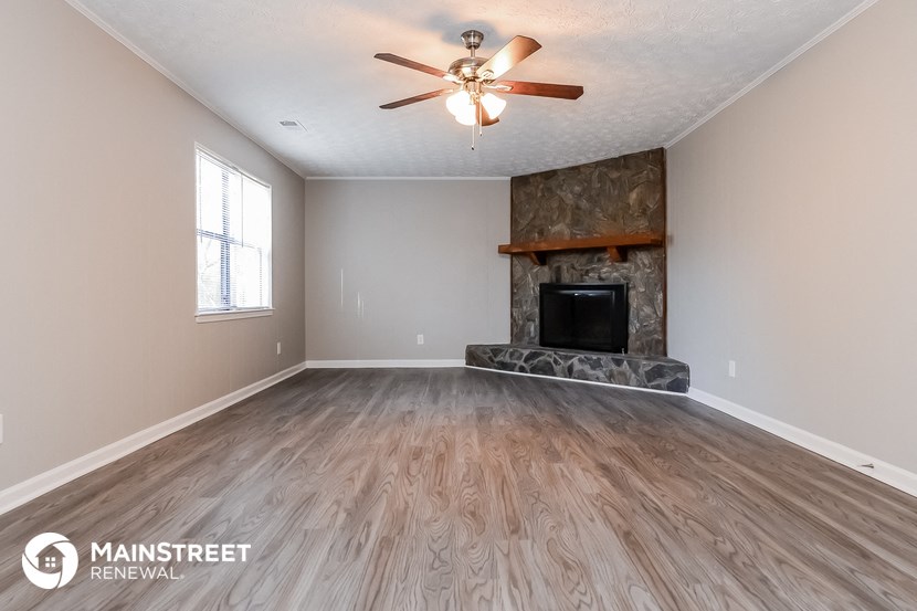 the living room has a fireplace and hardwood floors