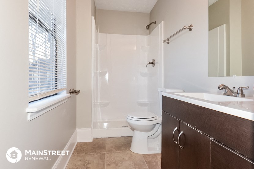 a bathroom with a toilet and a sink and a shower