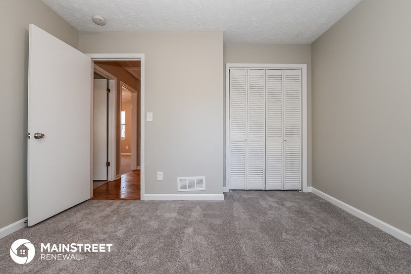 a bedroom with a closet and a door to a hallway