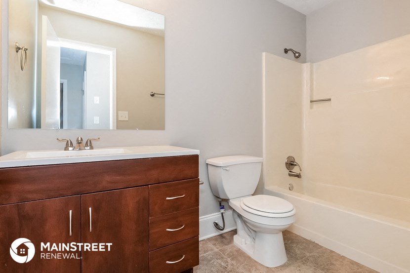 a bathroom with a toilet sink and a mirror