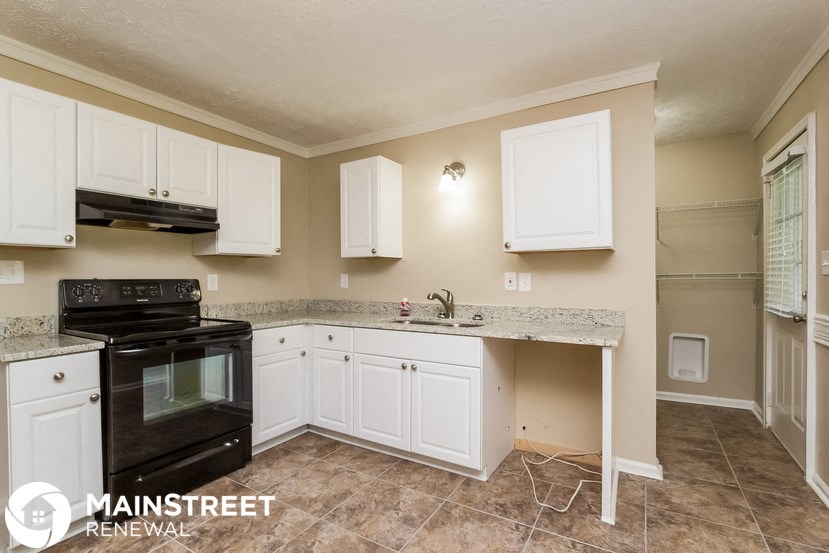 a kitchen with white cabinets and a counter top