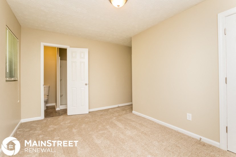 a spacious living room with a door to the bathroom