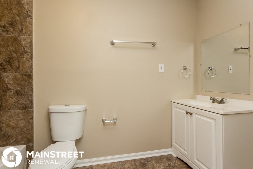 a bathroom with a toilet and a sink and a mirror
