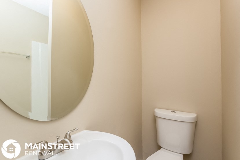 a bathroom with a toilet and a sink and a mirror