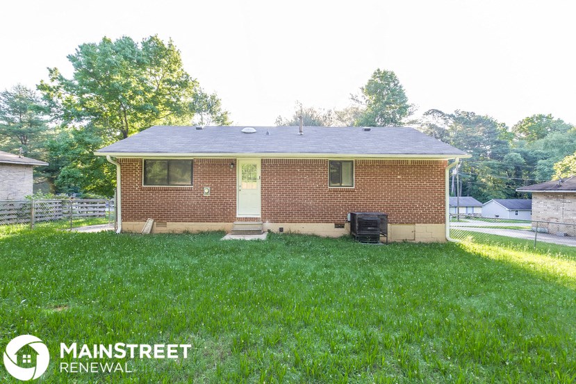 the front of a brick house in a grassy yard