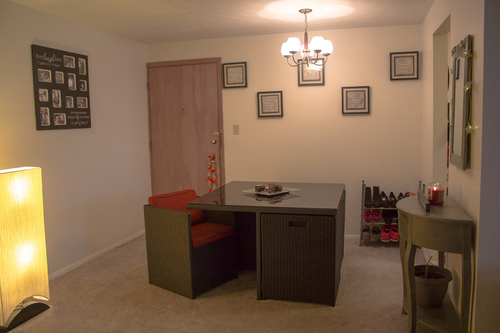a dining room with a table and a chair and a side table