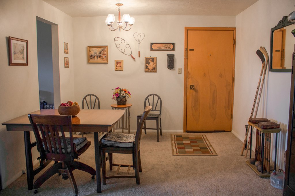 a dining room with a table and chairs and a wooden door