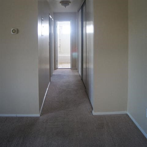 a hallway with a carpeted floor and white walls