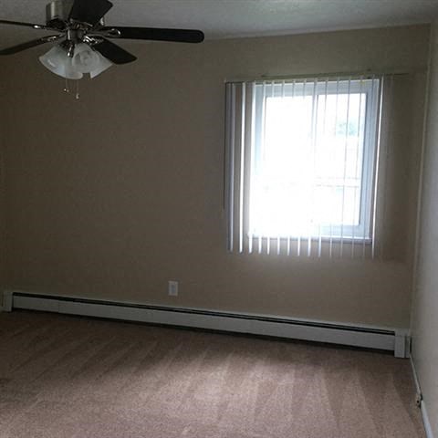 a living room with a ceiling fan and a window