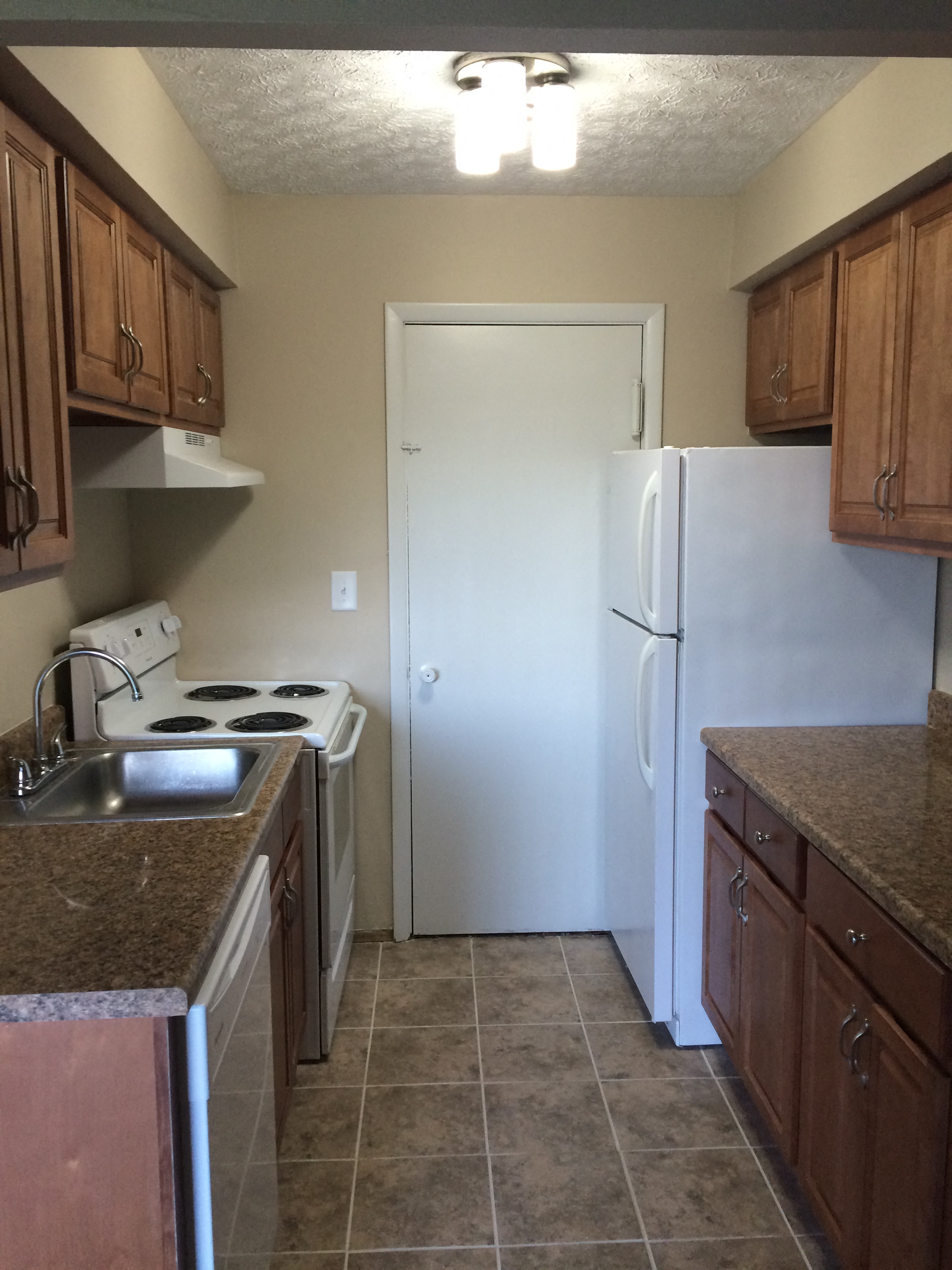 a kitchen with a white refrigerator and a sink