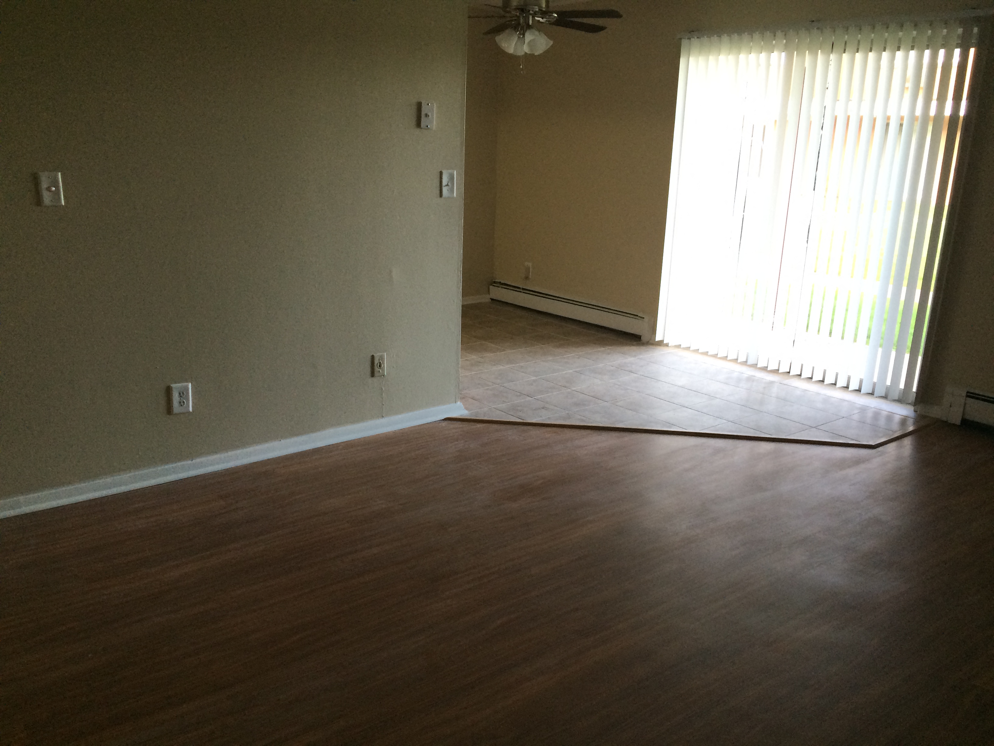 an empty living room with a wood floor and a window