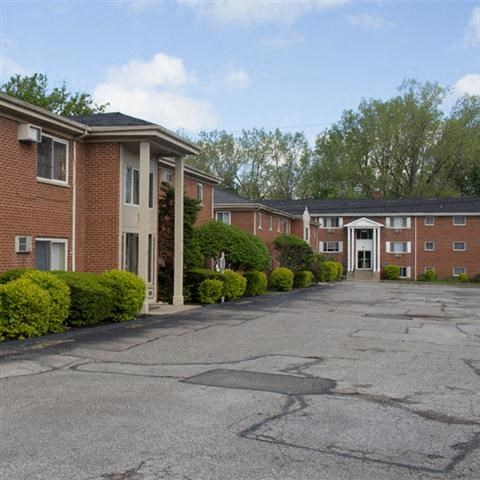 an empty parking lot in front of an apartment building