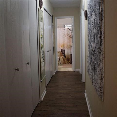 a hallway with a wooden floor and a door