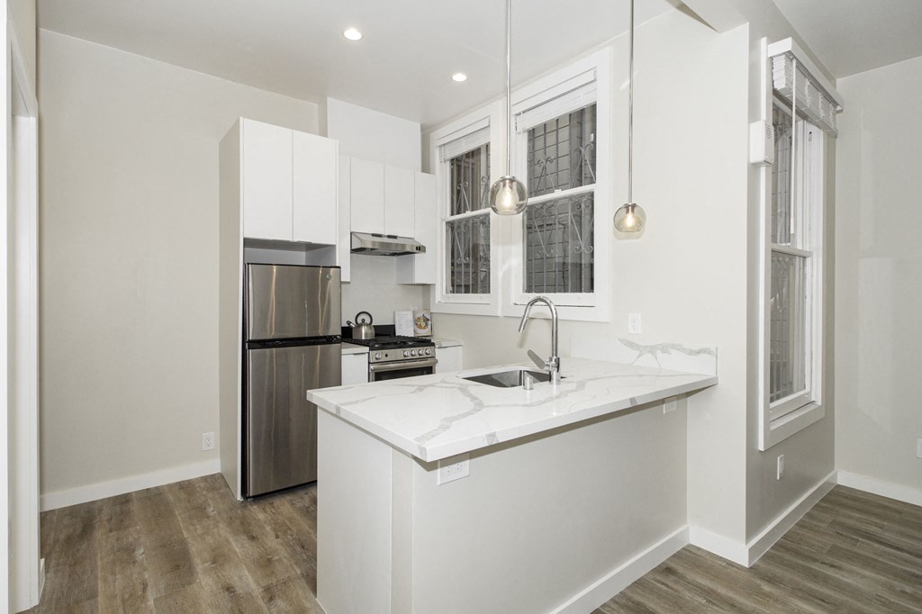 a renovated kitchen with white cabinets and a white counter top