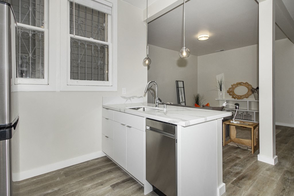 a kitchen with white cabinets and a stainless steel dishwasher