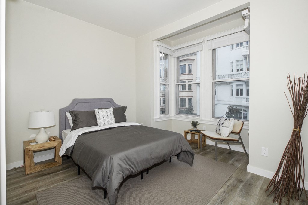 a bedroom with a bed and a large window