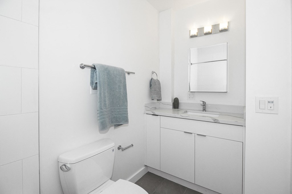 a white bathroom with a toilet and a sink
