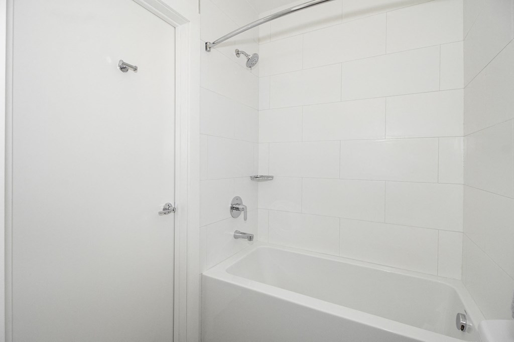 a white bathroom with a shower and a tub