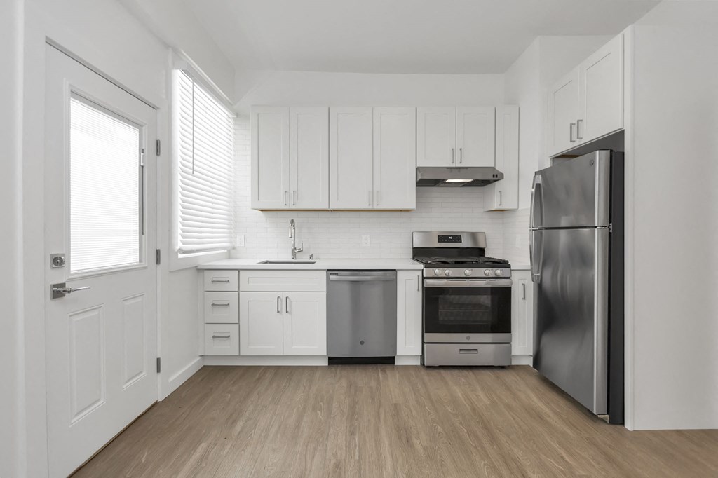 a kitchen with white cabinets and stainless steel appliances
