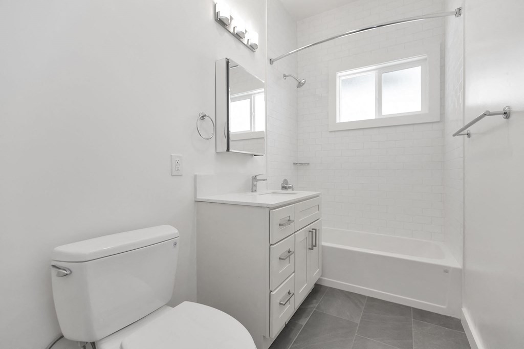 a white bathroom with a toilet and a sink