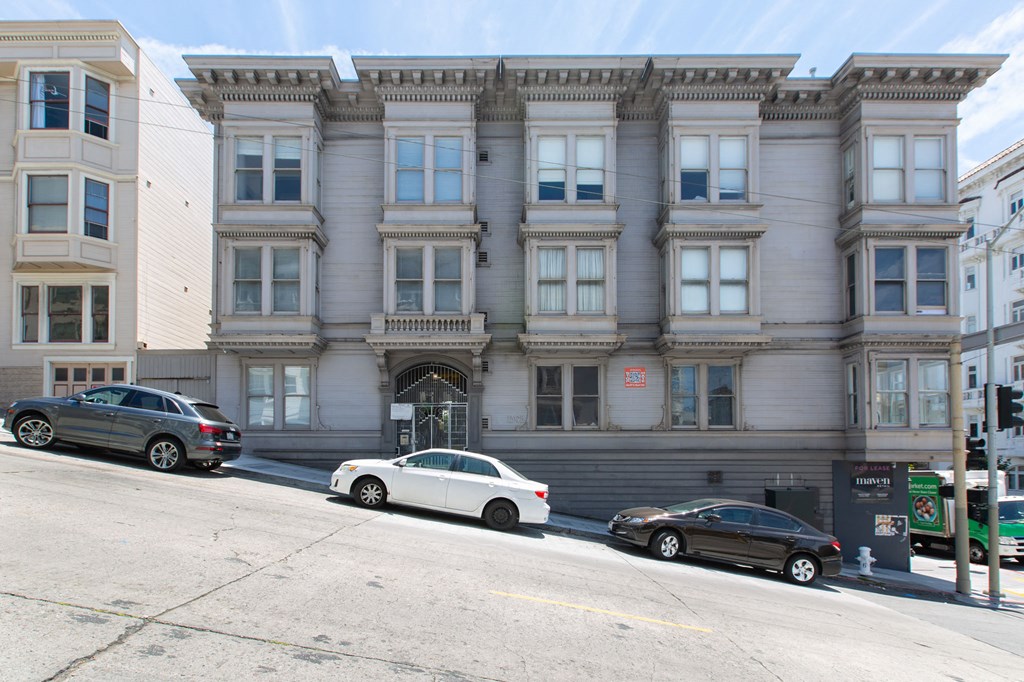 a building on a city street with cars parked in front