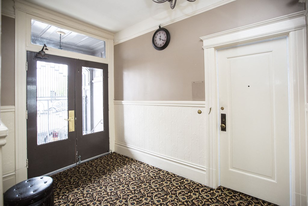 an empty room with a door and a clock on the wall
