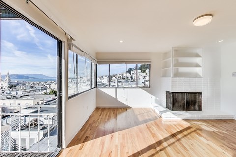 A modern room with a fireplace and a view of the city.