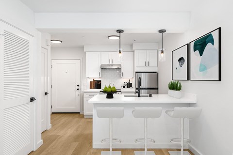 a kitchen with a large island and white cabinets